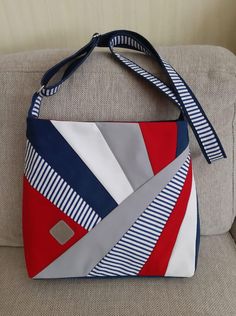 a red, white and blue purse sitting on top of a couch