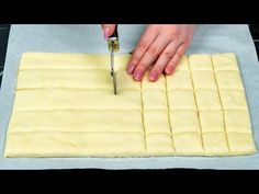 a woman is cutting dough into squares with a knife