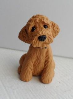 a brown dog figurine sitting on top of a white table next to a wall