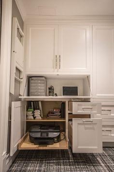 a kitchen with white cabinets and drawers