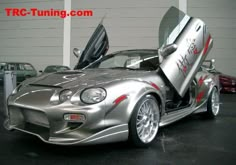 a silver sports car with its doors open