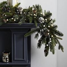 a christmas mantle with pine cones and lights