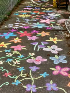 the sidewalk is decorated with colorful chalk flowers