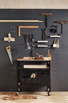 a workbench with tools hanging on the wall and pegs all around it