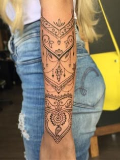 a woman's arm with an intricate tattoo design on her left forearm and wrist