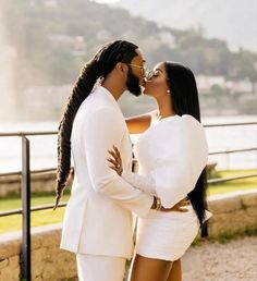 a man and woman in white clothes kissing each other