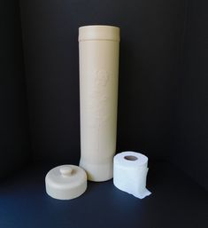 two rolls of toilet paper sitting next to a roll of toilet paper on a table