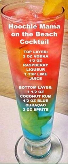 a tall glass filled with colorful drinks on top of a table