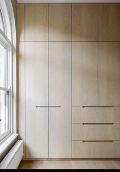 an empty room with wooden cabinets and windows