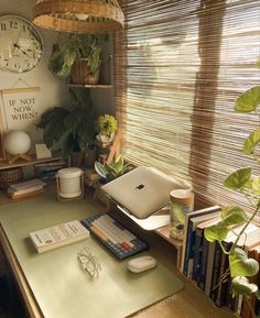 a laptop computer sitting on top of a desk next to a lamp and bookshelf