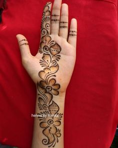 a woman's hand with henna tattoos on it