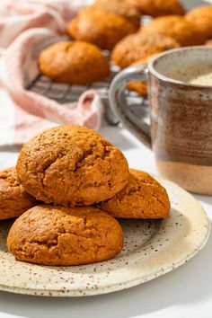 some muffins on a plate next to a cup of coffee