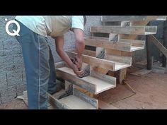 a man is working on some stairs made out of pallet wood and plywood