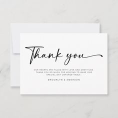 a white thank card with the words, thank you on it and black ink in script