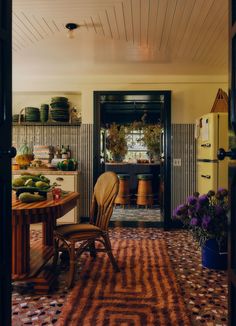 a dining room with a table and chairs next to an open door that leads into the kitchen