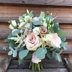 a bouquet of flowers sitting on top of a wooden bench