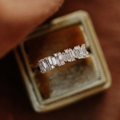 an engagement ring with three baguettes in it sitting on top of a box