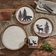 three plates with moose and pine trees on them