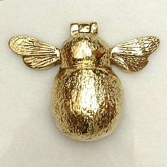 a gold colored figurine shaped like a bee