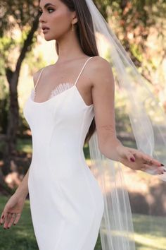 a woman in a white wedding dress and veil