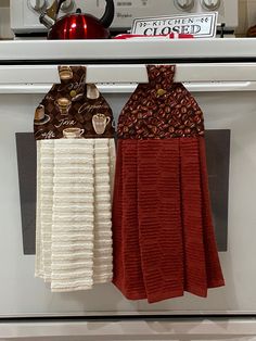 two tea towels hanging from the front of an oven