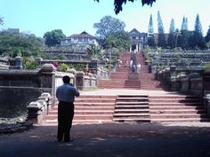 a man is standing in front of some steps and looking at the ground below him