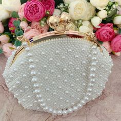 This luxurious encrusted pearl bridal clutch never fails to turn heads with its understated elegance and classic design. Adorned with varying sized White pearls and enhanced with a large creamy pearl clasp, this bridal clutch is the very picture of refinement. This elegant bridal clutch features rose gold trim, attachable chain and large enough for your phone. Complete your list of must-have wedding accessories with the ultimate bridal accessory to finish off your look and storing your wedding d Formal Pearl White Evening Bag, Pearl White Clutch With Pearl Embroidery For Events, White Pearl Clutch For Events, Wedding Embellished Pearl Evening Bag, Elegant Pearl Wedding Bags, Pearl White Clutch With Pearl Embroidery For Formal Events, Pearl White Evening Bag With Pearl Handle For Wedding, Formal Pearl White Clutch With Pearl Embroidery, Cream Pearl Evening Bag For Wedding