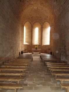 an empty church with pews and stone walls