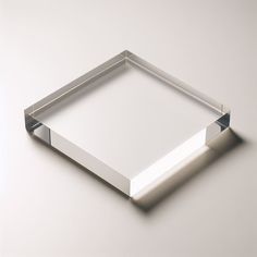 an empty square shaped object on a white surface with light coming through the middle and reflecting off it's sides