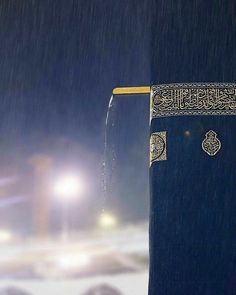 an open book with arabic writing on it in the rain at night, next to a street light