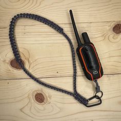 a walkie talkie attached to a lanyard on a wooden floor with wood planks