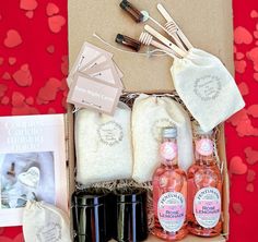 the contents of a gift box are laid out on a red tablecloth with hearts