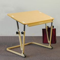 a small wooden table sitting on top of a carpeted floor next to a red bag