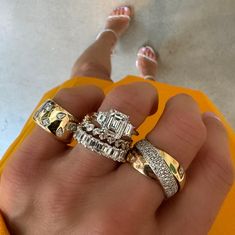 a person's hand holding two wedding rings