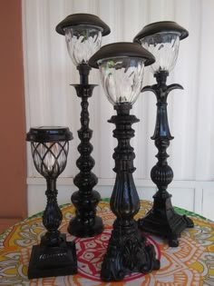 three black lamps sitting on top of a table