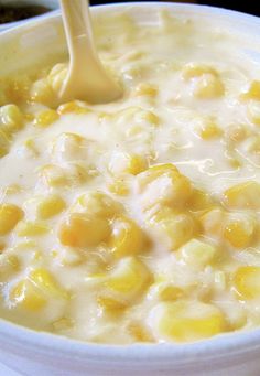 a white bowl filled with corn on top of a table