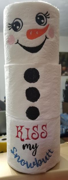 a toilet paper roll with the words kiss my snowman on it and a face drawn on it