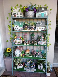 a shelf filled with potted plants and figurines