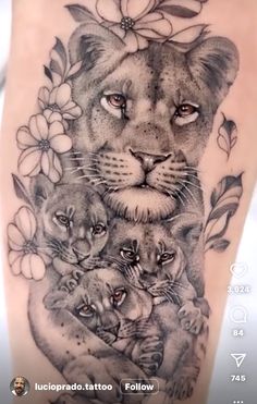 a woman's thigh with a lion and cubs tattoo on her leg, which is surrounded by flowers