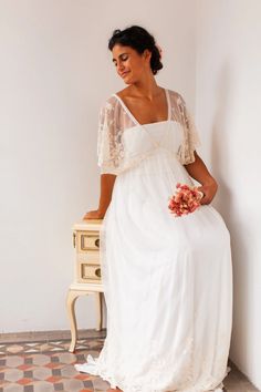 a woman in a white dress sitting on a table