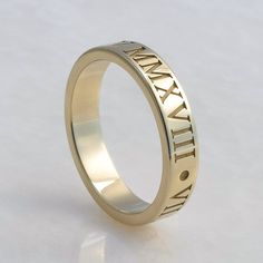 This is a personalized Roman Numeral band in solid 14K gold. The date of your choice is written in Roman Numerals twice around the ring(with a dot in between them)  Features of the ring:    -Date of your choice is written twice around the band. Or instead, you can choose two  different dates.    -Font is Times New Roman, which is cast right into the ring to give the letters plenty of depth    -Band is 4mm wide and 1.5mm thick.     -Made to order in your size.    - Your choice of 14K yellow, whit Yellow Gold Open Band For Anniversary, Anniversary Bands With Engraving Option, Anniversary Band With Engraving Option, 14k Gold Open Band For Anniversary, Classic 14k Rose Gold Promise Jewelry, Timeless Jewelry For Anniversary With Hallmarks, Engraved 14k Gold Promise Ring, Yellow Gold Promise Rings With Hallmarks, Gold Open Band For Anniversary