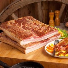 two plates with food on them sitting on a wooden table next to a basket of fruit