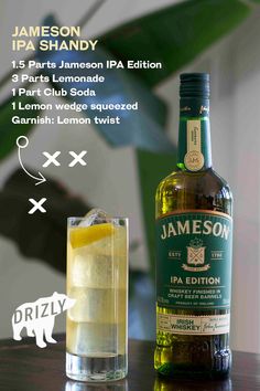 a bottle of jameson on a table next to a glass with ice and lemon in it