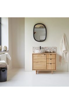 a bathroom with a sink, mirror and towel on the rack in front of it