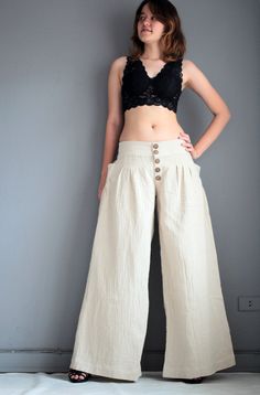 "This 4 size pants is made of 100% cotton fabric. Simple in design, gathered front, with zipper and 5 buttons. Elastic in the back for flexibility. Low waist design. Super cute pocket on both sides feathering fan shape gathering. Long wide leg. Elegant piece.Flattering to most shape. Measurement; S Low waist max 28-36\" Hip max 42\" Length out seam 39\" Length inseam 30\" M Low waist max 36-39\" Hip max 44\" Length out seam 40\" Length inseam 31\" L Low waist max 39-40\" Hip max 46\" Length out High-waisted Cotton Harem Pants In Beige, Beige High-waisted Cotton Harem Pants, Beige Wide Leg Bottoms With Buttons, Beige Wide-leg Bottoms With Buttons, High Waist Linen Bottoms With Buttons, High Waist Beige Cotton Harem Pants, Chic Cotton Harem Pants With Pockets, High Waist Cotton Wide Leg Pants With Buttons, High-waist Wide Leg Cotton Pants With Buttons