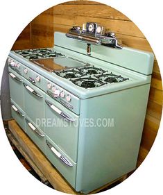 an old fashioned stove with two burners on it's sides in front of a wooden wall