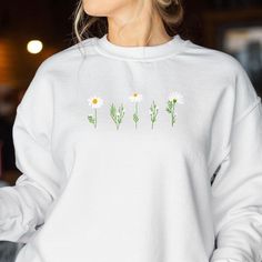 🌸 Blossom in Style! Embrace the beauty of nature every day with our stunning Embroidered Daisy Sweatshirt. Ideal for any nature lover or plant lady, this sweatshirt is more than just clothing--it's a celebration of your love for all things floral and vintage. 🎁 A Gift That Blooms All Year Round: Whether you're shopping for Mother's Day, birthdays, or just because, this beautifully embroidered floral sweatshirt is the perfect gift for her. Delight the nature enthusiast in your life with a styli White Crew Neck Top With Floral Embroidery, White Floral Embroidery Sweatshirt For Spring, White Long Sleeve T-shirt With Floral Embroidery, Casual White Sweatshirt With Floral Embroidery, White Floral Embroidery Sweatshirt With Relaxed Fit, White Floral Embroidered Sweatshirt With Relaxed Fit, White Floral Embroidered Sweatshirt Relaxed Fit, White Relaxed Fit Sweatshirt With Floral Embroidery, Daisy Sweatshirt