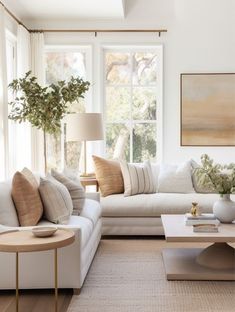 a living room filled with white furniture and pillows