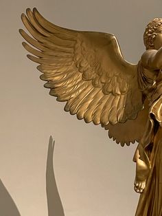 a golden angel statue with its wings spread