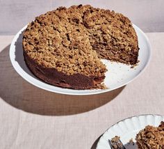 a piece of cake on a plate next to a fork and another slice is missing